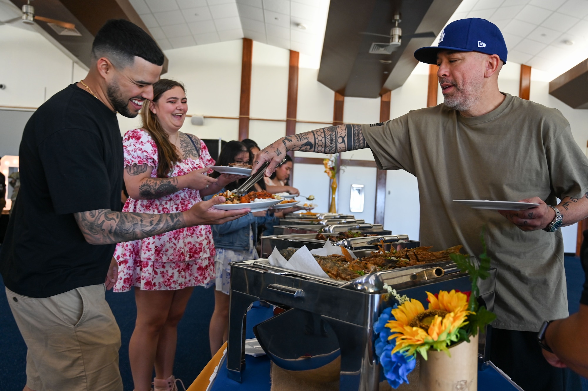 A U.S. Air Force Airman gets served food by American comedian and actor, Jo Koy, at the Sunrise Conference Center on Andersen Air Force Base, Guam, Feb. 1, 2025. Jo Koy visited the island as part of his USO comedy tour performing for military service members stationed in Japan and Guam. (U.S. Air Force photo by Airman 1st Class Natasha Ninete).