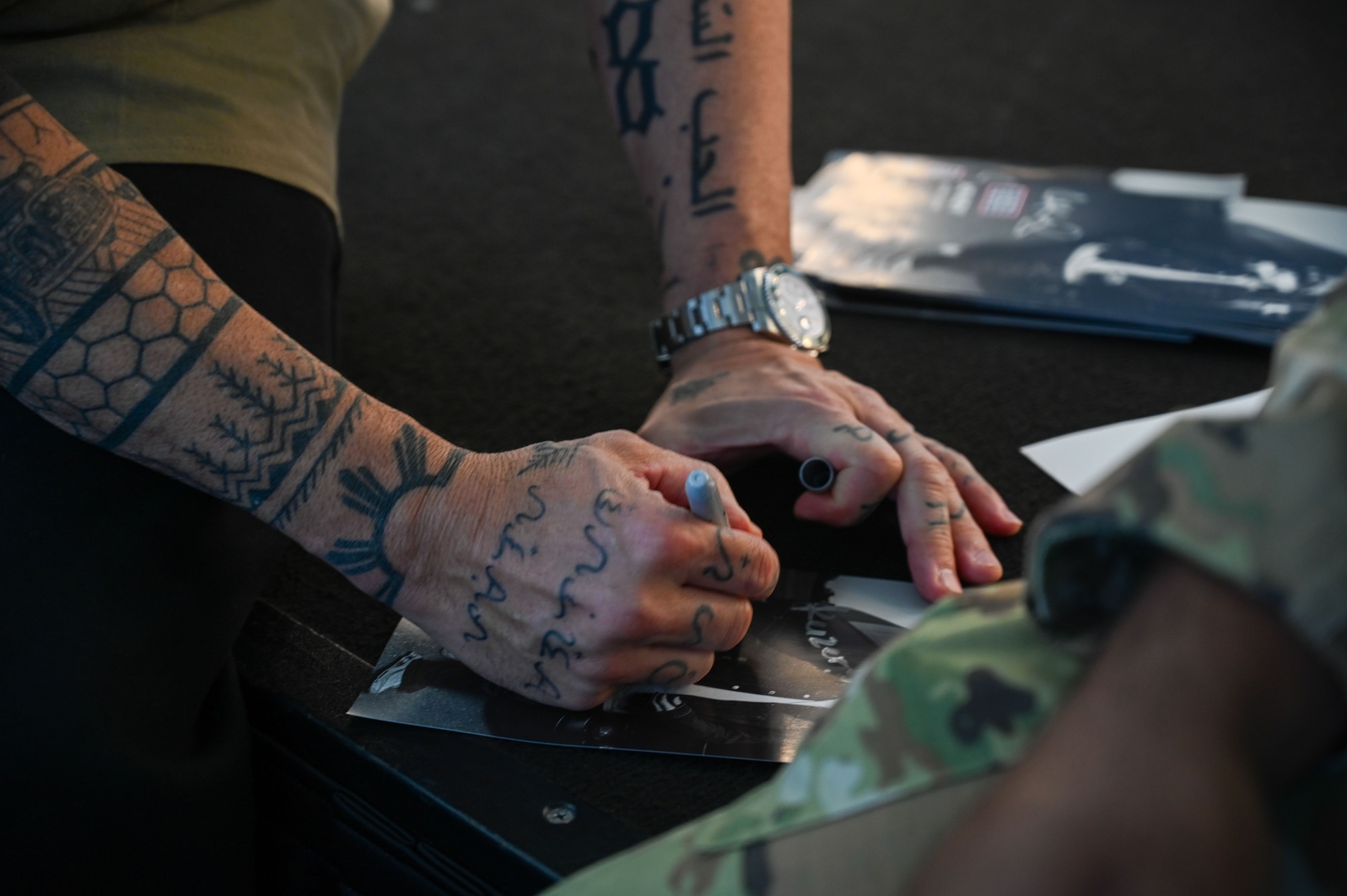 American comedian and actor, Jo Koy, autographs a photo at the Sunrise Conference Center on Andersen Air Force Base, Guam, Feb. 1, 2025. Jo Koy visited the island as part of his USO comedy tour performing for military service members stationed in Japan and Guam. (U.S. Air Force photo by Airman 1st Class Natasha Ninete).