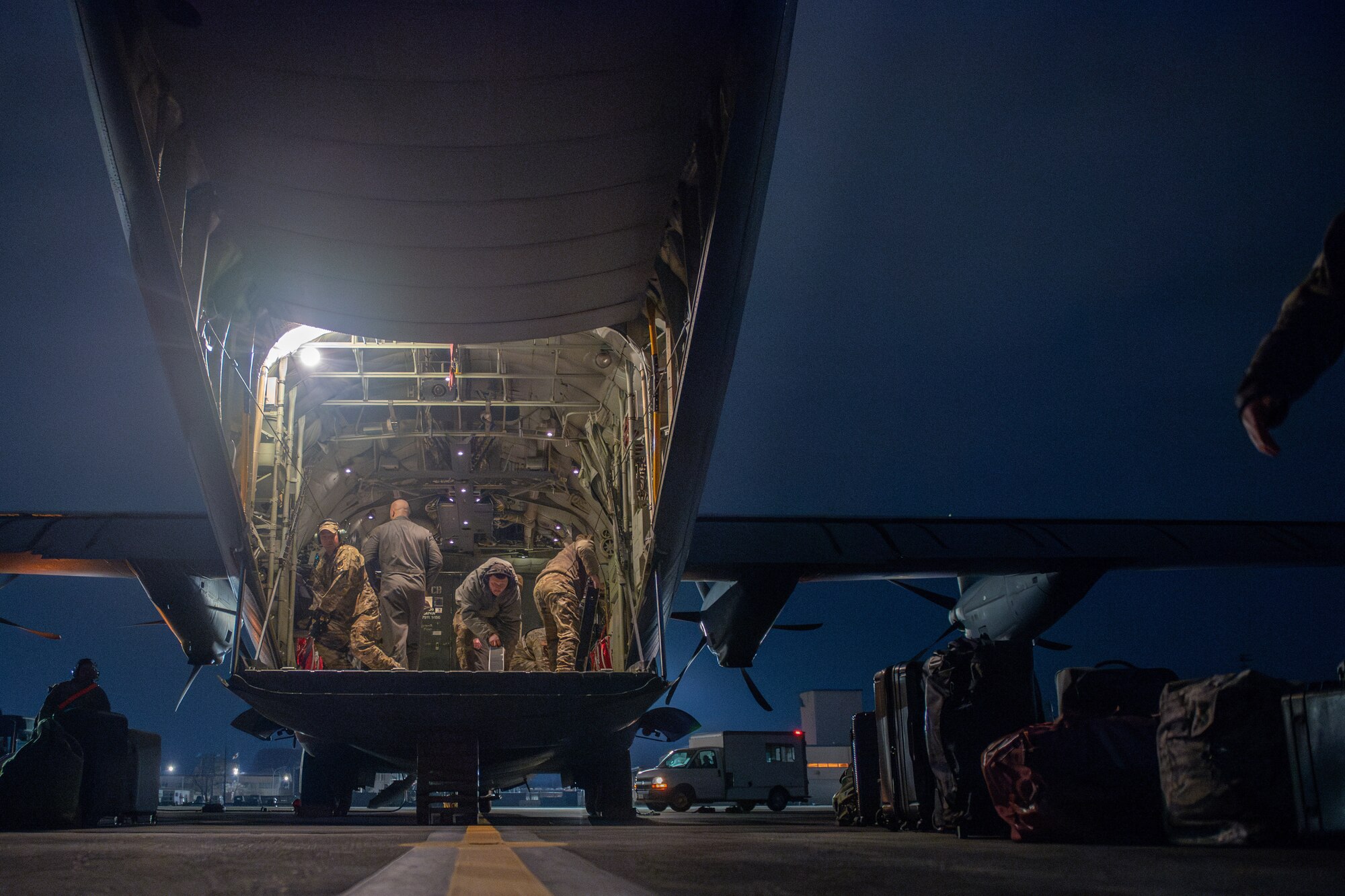 Airmen move around inside of an aircraft.