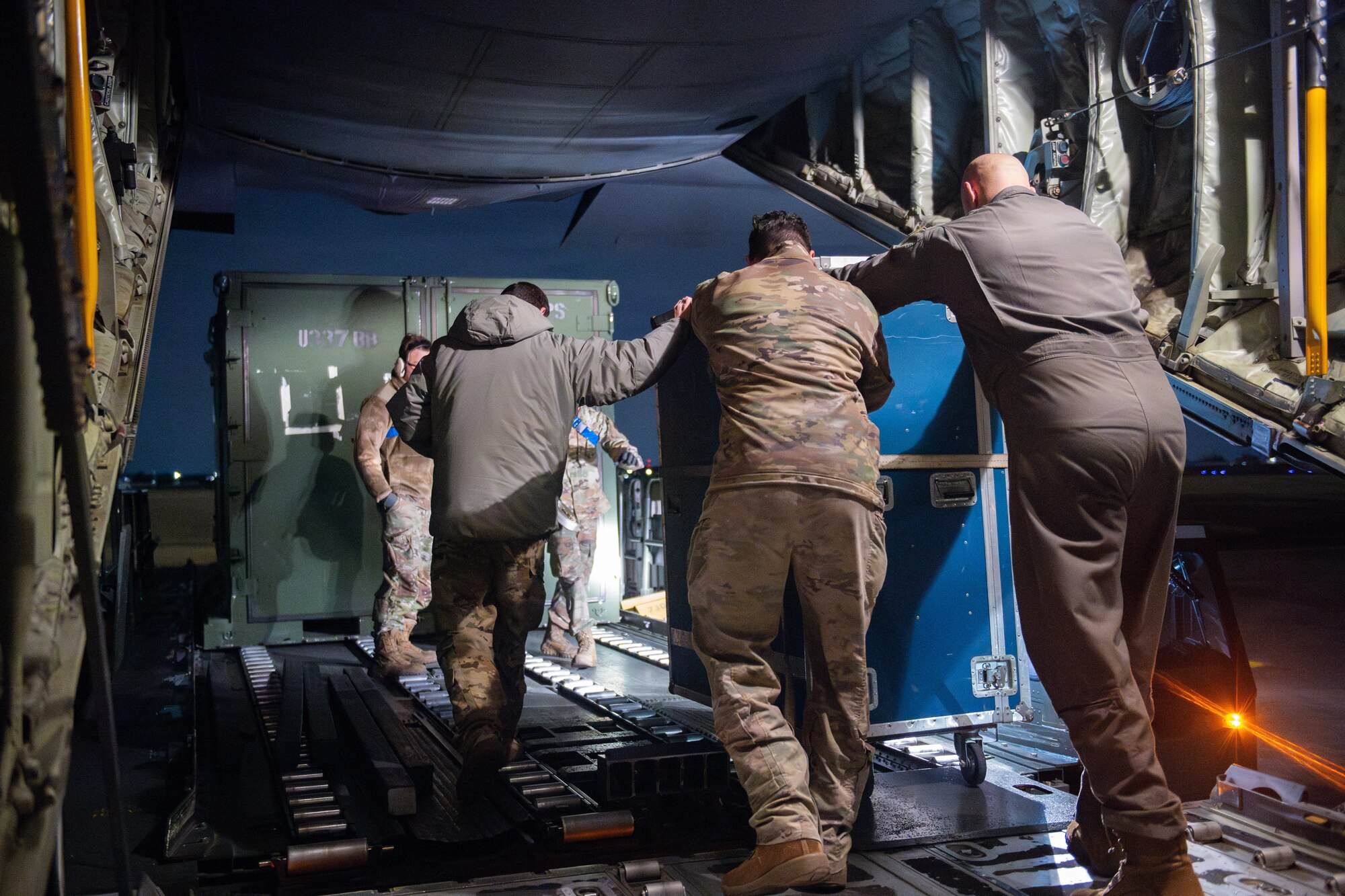 Airmen push a blue box.