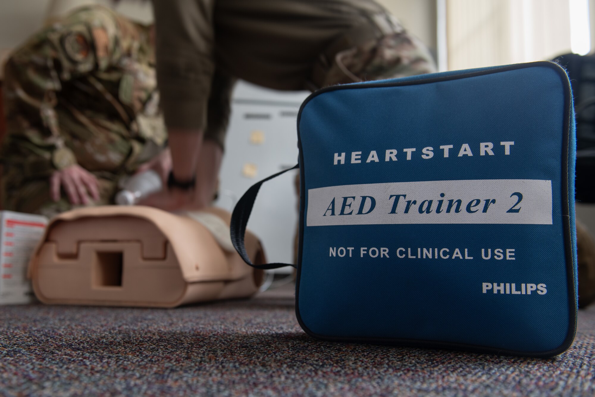 A blue medical equipment device bag sits on a carpet.