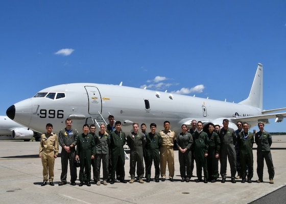 military members pose for a photo in front of military aircraft