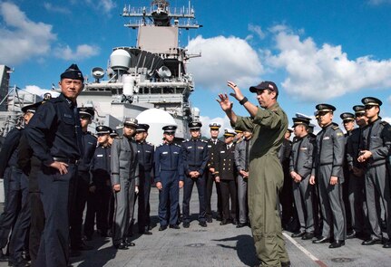 Official provides information for visiting military members onboard a military ship