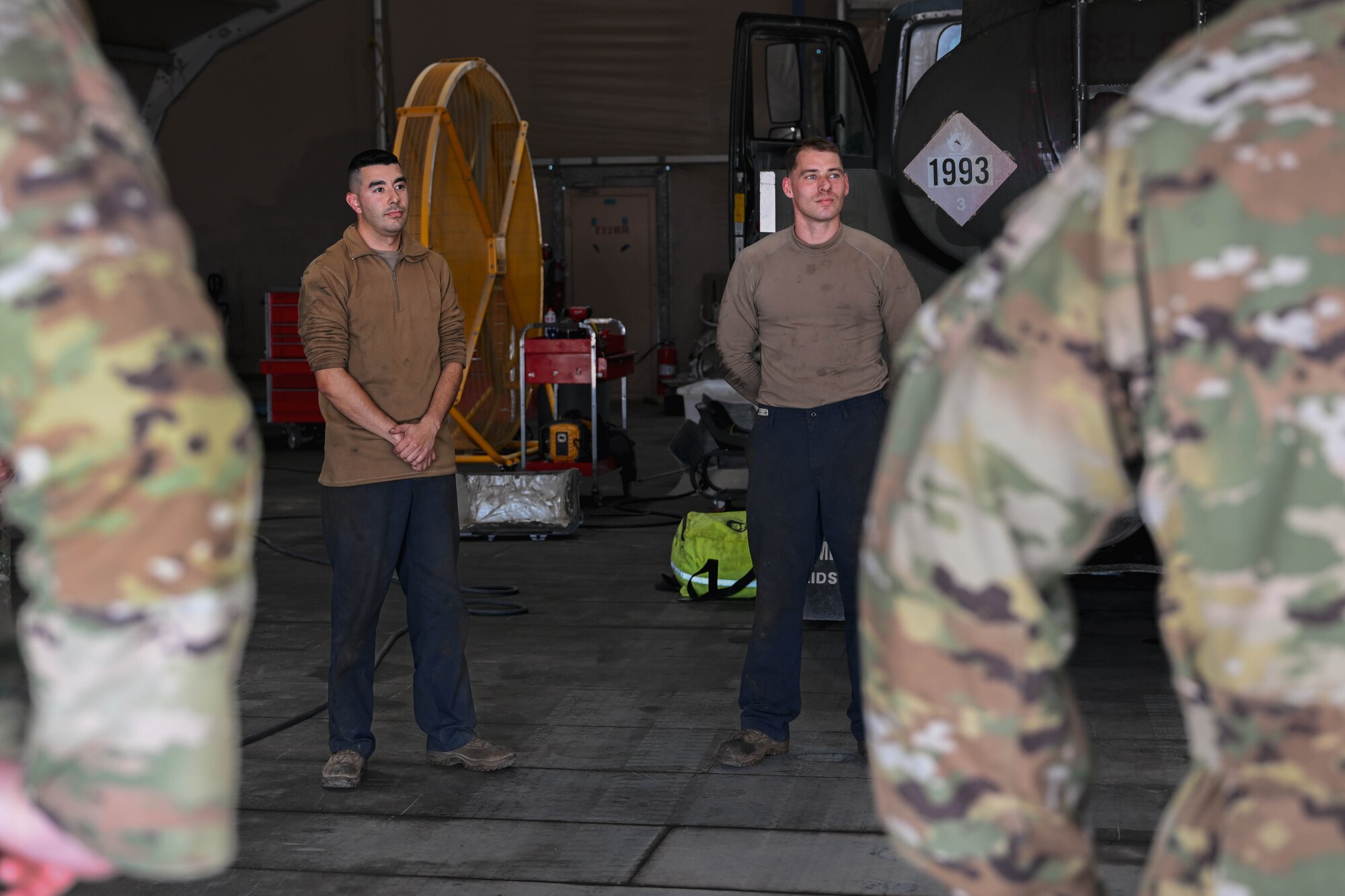 Men in work attire stand as they are recognized by men in uniform.