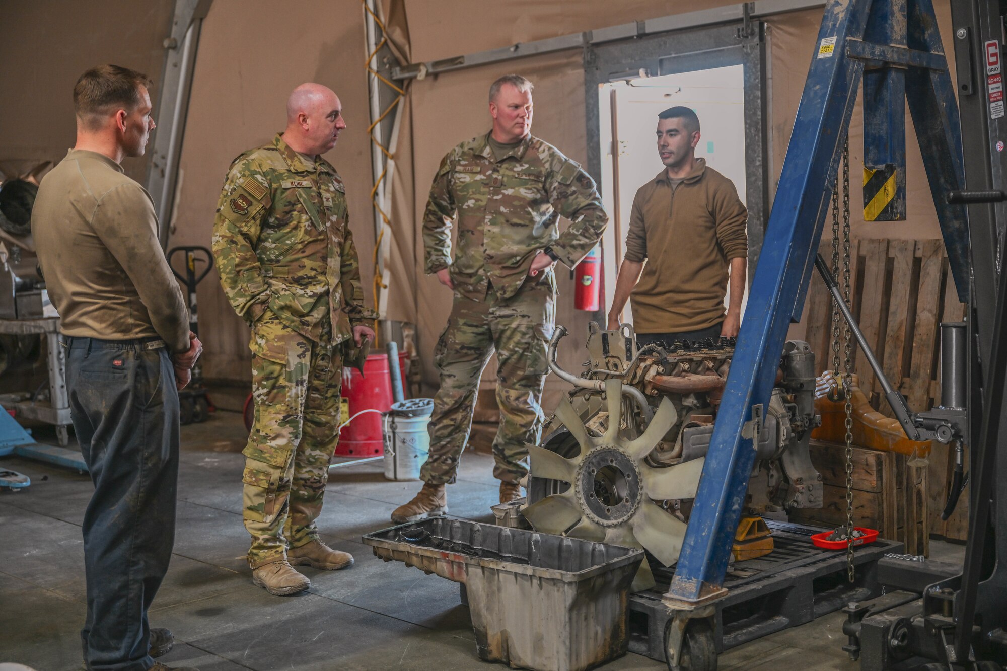 Men in uniform stand alongside an engine.