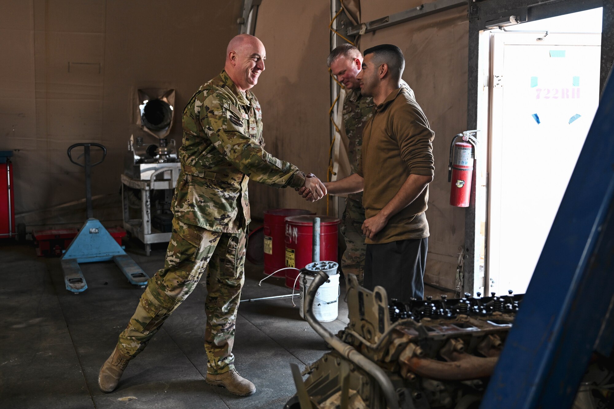 A man in uniform shakes a man's hand.