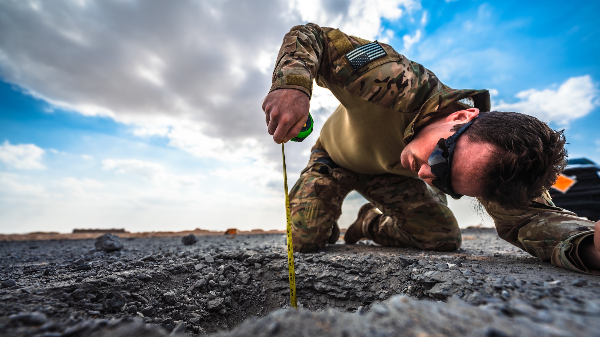 Airman inspects explosive crater