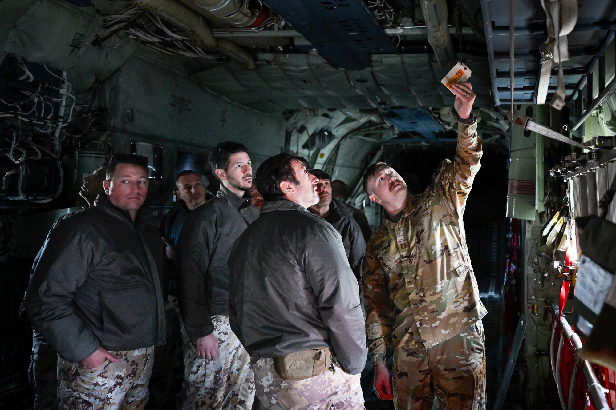 A U.S. Air Force Airman speaks to Italian Air Force personnel inside a C-130J aircraft.