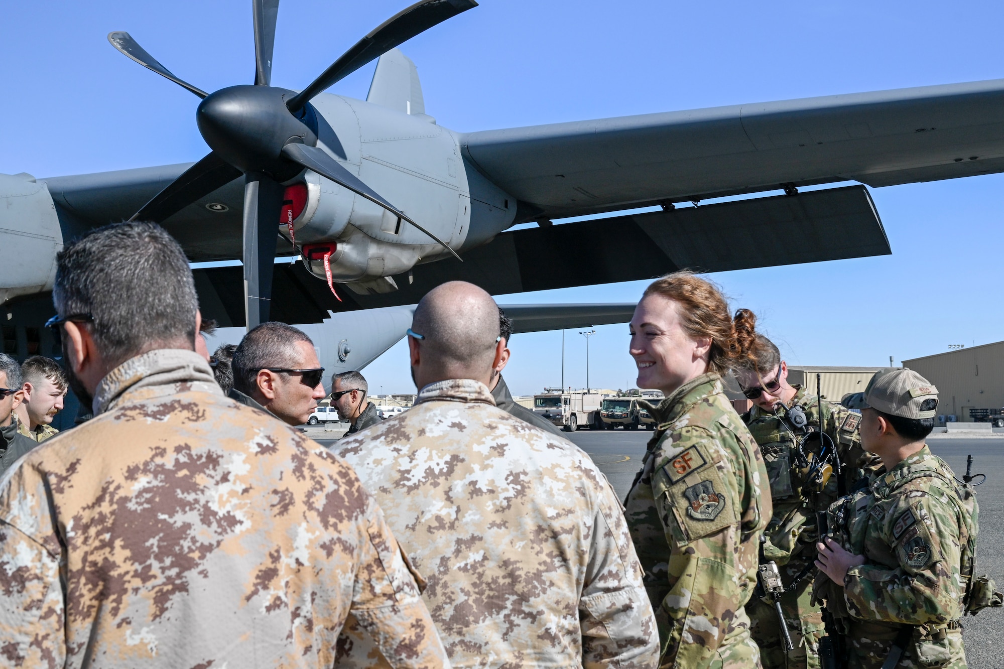 U.S. Air Force Airman and speak next to a C-130J aircraft.