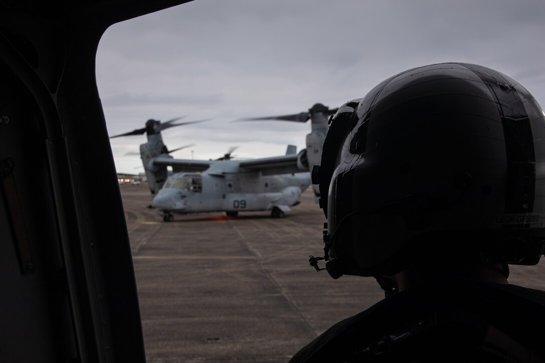 U.S. Marine Corps Gunnery Sgt. Gary Fleck, tiltrotor airframe mechanic with Marine Medium Tiltrotor Squadron (VMM) 774, Marine Aircraft Group 49, 4th Marine Aircraft Wing, waits for an MV-22 Osprey, tiltrotor aircraft, to move on Naval Air Station Joint Reserve Base New Orleans, Belle Chasse, Louisiana, Feb. 4, 2025. MV-22 Osprey pilots and flight crew with VMM-744, Marine Aircraft Group 49, 4th Marine Aircraft Wing and VMM-764, Marine Aircraft Group 41, 4th Marine Aircraft Wing conducted a flight rehearsal in preparation for the flyover during Super Bowl LIX. (U.S. Marine Corps photo by Lance Cpl. Van Hoang)