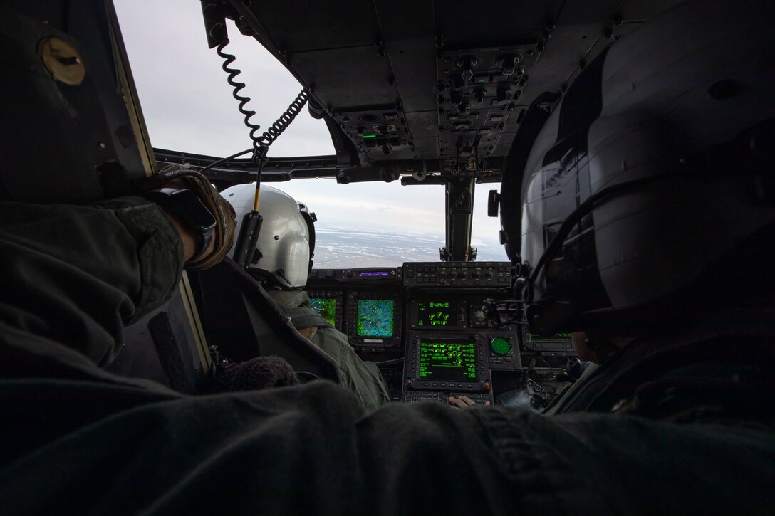 U.S. Marine Corps Gunnery Sgt. Gary Fleck, tiltrotor airframe mechanic with Marine Medium Tiltrotor Squadron (VMM) 774, Marine Aircraft Group 49, 4th Marine Aircraft Wing, talks to the pilots while flying over New Orleans, Feb. 4, 2025. MV-22 Osprey pilots and flight crew with VMM-744, Marine Aircraft Group 49, 4th Marine Aircraft Wing and VMM-764, Marine Aircraft Group 41, 4th Marine Aircraft Wing conducted a flight rehearsal in preparation for the flyover during Super Bowl LIX. (U.S. Marine Corps photo by Lance Cpl. Van Hoang)