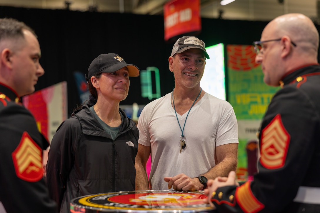 U.S. Marine Corps Sgt. Nicholas Cole, (left), airframes mechanic, Marine Medium Tiltrotor Squadron (VMM) 774, 4th Marine Aircraft Wing, and Gunnery Sgt. John Rethage, aviation electronics technician, Marine Medium Tiltrotor Squadron (VMM) 774, 4th Marine Airwing, interact with attendees during the NFL’s Super Bowl Fan Zone Experience at the Ernest N. Morial Convention Center, New Orleans, Feb. 5, 2025. Marines from Marine Medium Tiltrotor Squadron (VMM) 774 and 764 participated in the experience, giving them the opportunity to interact with the American public, increase knowledge about the Marine Corps Reserve and kickoff the celebration of the U.S. Marine Corps’ 250th birthday. (U.S. Marine Corps Photo by Lance Cpl. Juan Diaz)