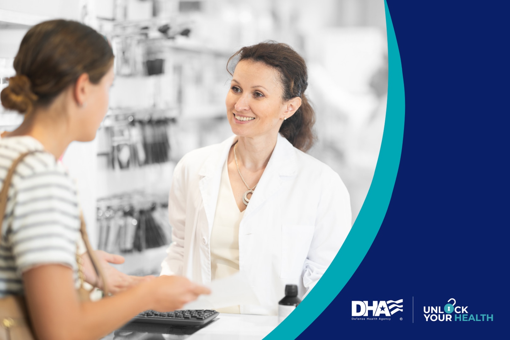 Female pharmacist wearing white lab coat stands behind pharmacy counter speaking to female patient.