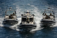 Boat crew members with Maritime Security Response Team West maintain a formation astern Pierce County Ferry Steilacoom II after transferring boarding teams to clear the ferry of simulated threats during a tactical exercise