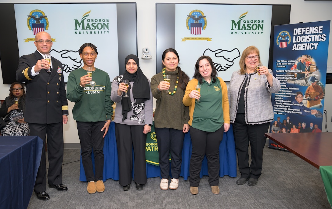 Six people pose for photo at ceremony.
