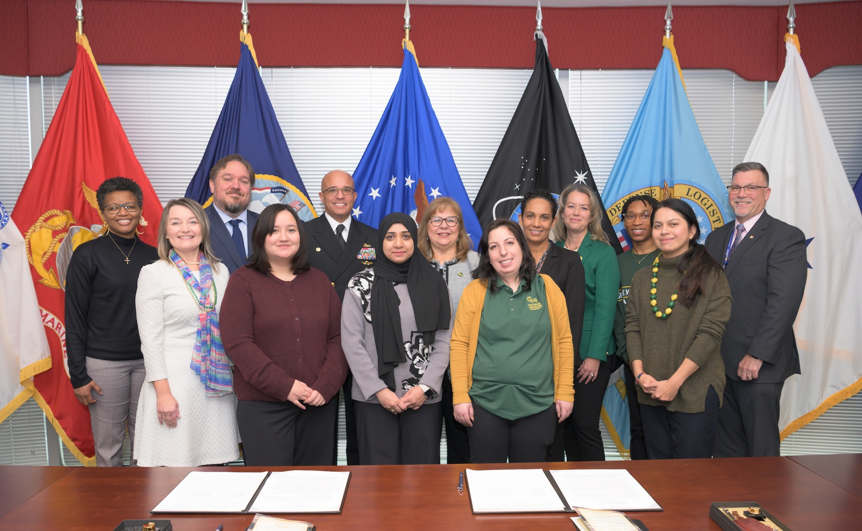Defense Logistics Agency Energy staff and George Mason University students pose for a group picture after the re-signed an updated Memorandum of Understanding.
