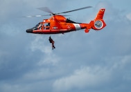 Coast Guard Petty Officer 3rd Class Garrett Nims, an Aviation Survival Technician at Coast Guard Air Station Barbers Point, is hoisted up to the helicopter while conducting training with the Red Raven