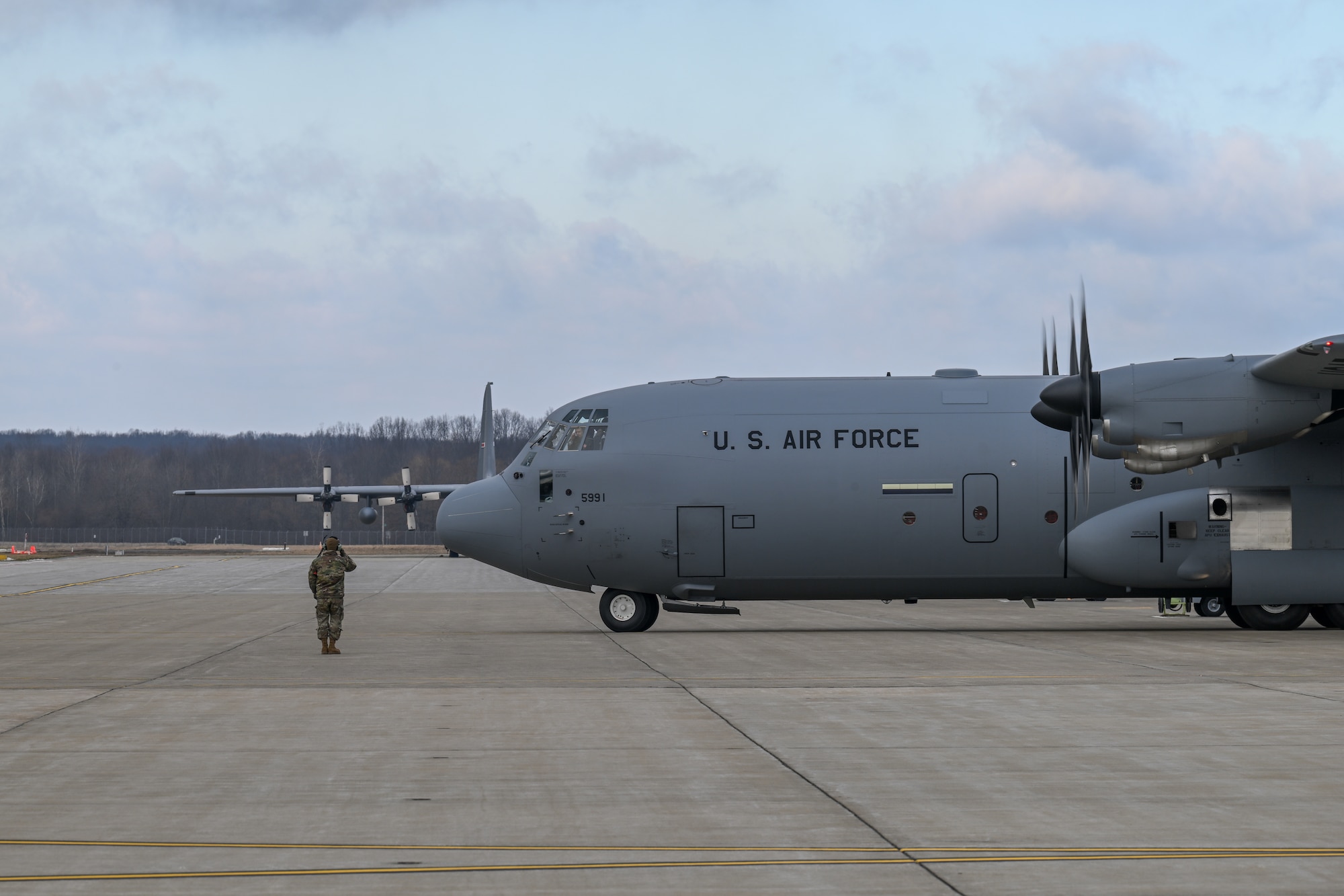 A 910th Aircraft Maintenance Squadron member salutes as a C-130J-30 Super Hercules aircraft begins its taxi to the runway for a two-aircraft formation flight at Youngstown Air Reserve Station, Ohio, Feb. 4, 2025.