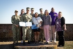 Hospital Corpsman Third Class Jeovony Cameron, center, with certificate, reenlisted in the U.S. Navy during a ceremony conducted Tuesday, February 4, 2025 at Fort Macon State Park North Carolina.