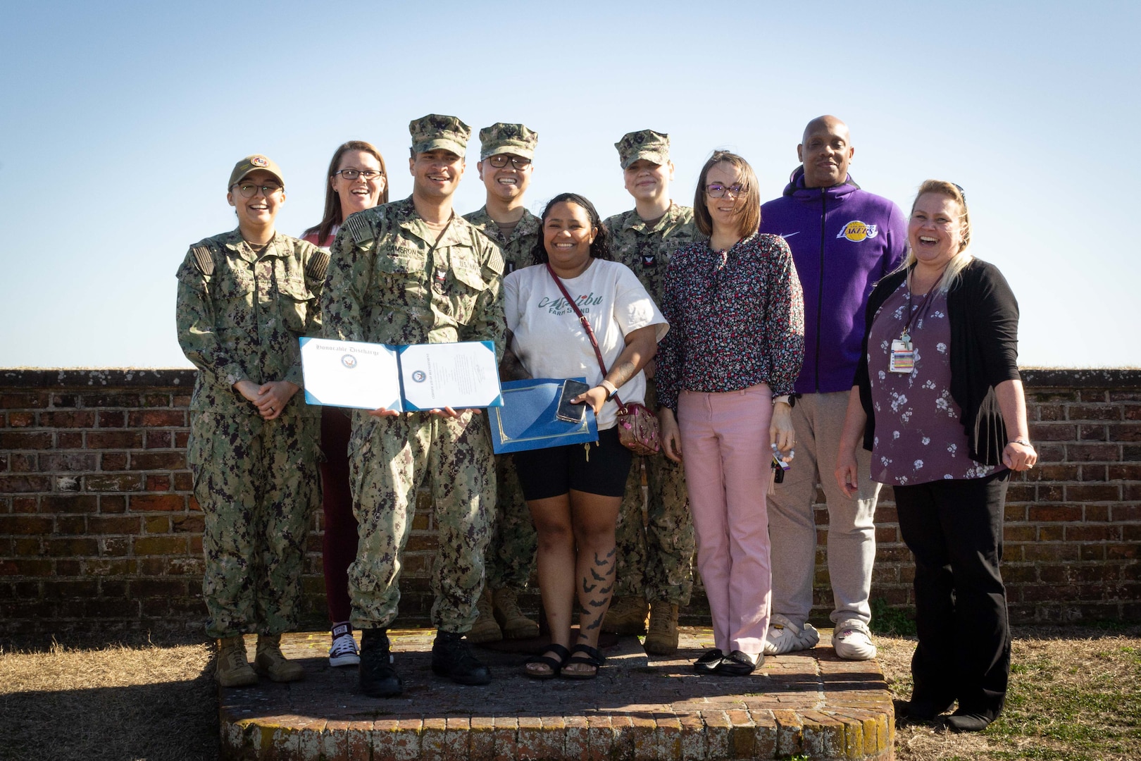 Hospital Corpsman Third Class Jeovony Cameron, center, with certificate, reenlisted in the U.S. Navy during a ceremony conducted Tuesday, February 4, 2025 at Fort Macon State Park North Carolina.