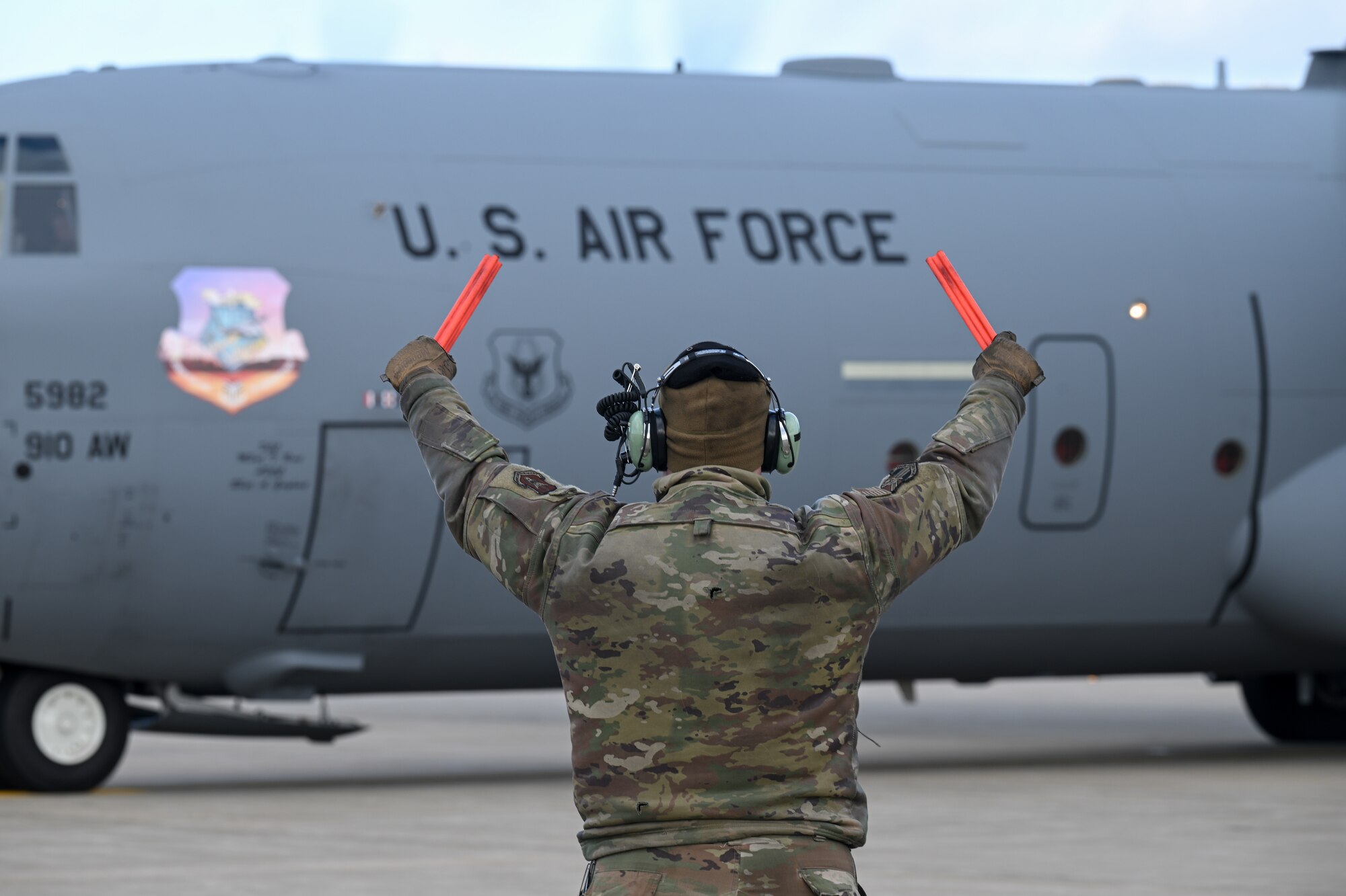 A 910th Aircraft Maintenance Squadron member marshals a C-130J-30 Super Hercules aircraft as it begins its taxi to the runway for a two-aircraft formation flight at Youngstown Air Reserve Station, Ohio, Feb. 4, 2025.