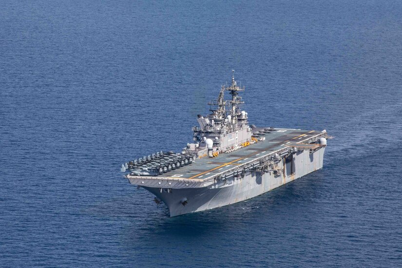 An overhead view of a large military warship sailing in the ocean.