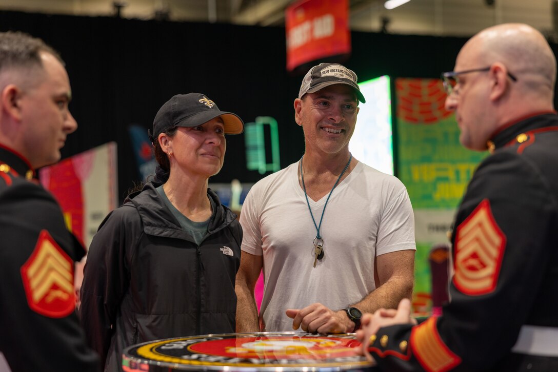 U.S. Marine Corps Sgt. Nicholas Cole, (left), airframes mechanic, Marine Medium Tiltrotor Squadron (VMM) 774, 4th Marine Aircraft Wing, and Gunnery Sgt. John Rethage, aviation electronics technician, Marine Medium Tiltrotor Squadron (VMM) 774, 4th Marine Airwing, interact with attendees during the NFL’s Super Bowl Fan Zone Experience at the Ernest N. Morial Convention Center, New Orleans, Feb. 5, 2025. Marines from Marine Medium Tiltrotor Squadron (VMM) 774 and 764 participated in the experience, giving them the opportunity to interact with the American public, increase knowledge about the Marine Corps Reserve and kickoff the celebration of the U.S. Marine Corps’ 250th birthday. (U.S. Marine Corps Photo by Lance Cpl. Juan Diaz)