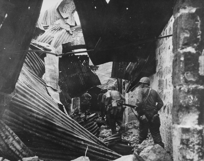 U.S. soldiers advance through a war-torn city.
