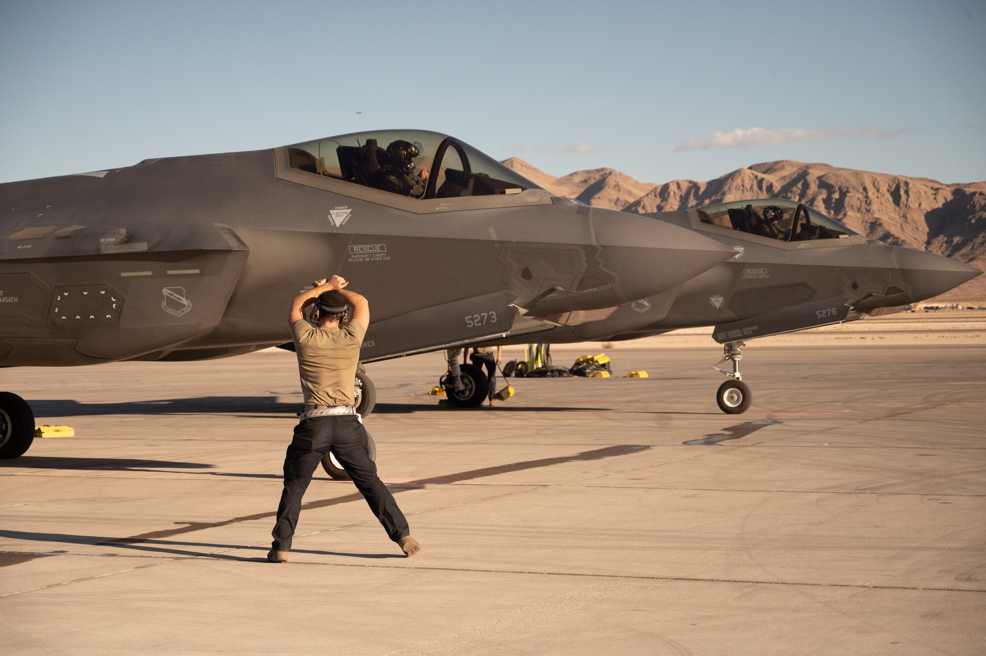 An F-35 maintainer marshals a jet