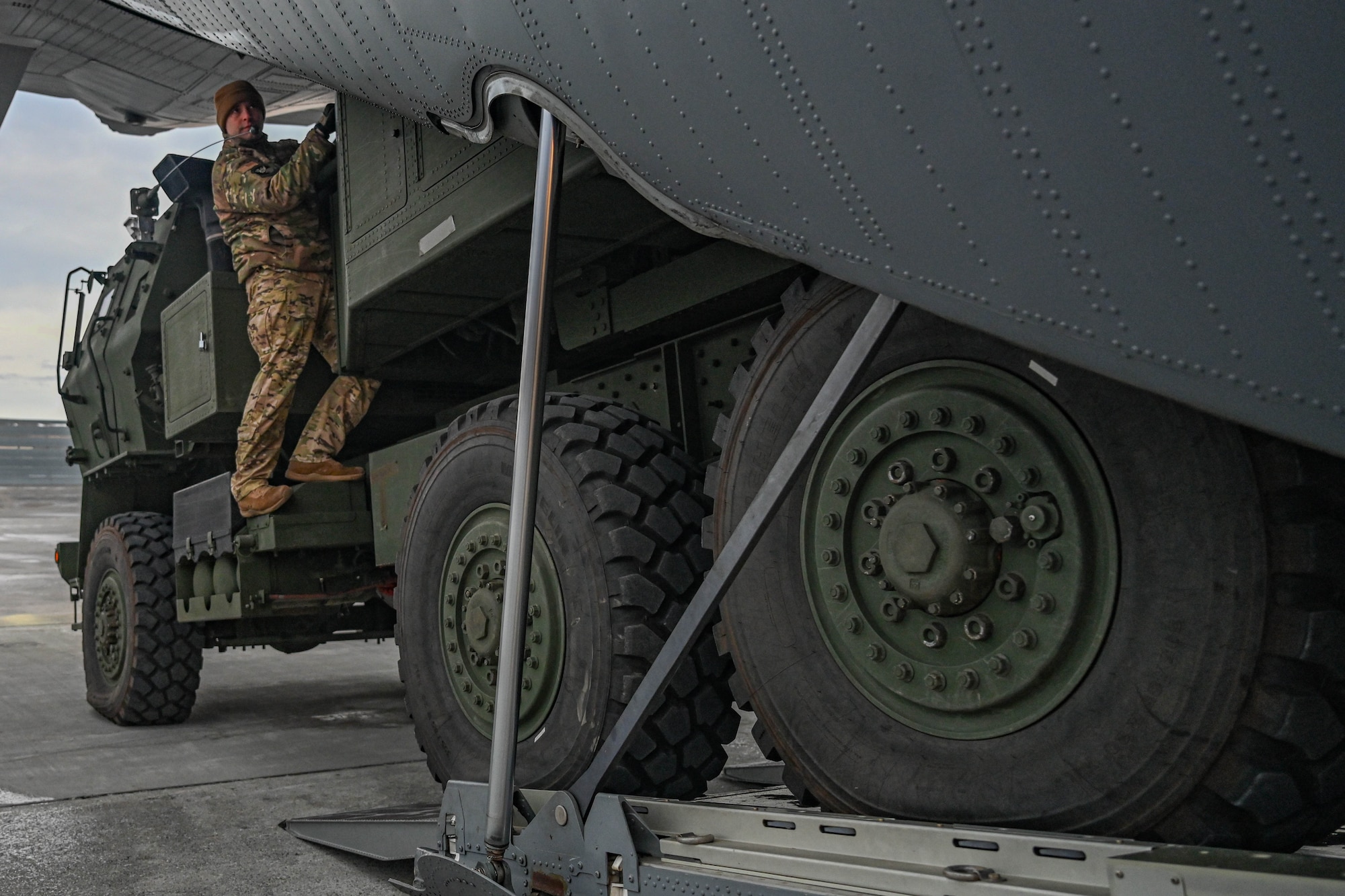 A High Mobility Artillery Rocket System (HIMARS) vehicle, assigned to the 1st Battalion, 11th Field Artillery Regiment, is loaded into a C-130J Super Hercules aircraft during the Joint Pacific Multinational Readiness Center (JPMRC) 25-02 exercise at Joint Base Elmendorf-Richardson, Alaska, Jan. 18, 2025. The C-130 aircraft is capable of operating from rough, dirt strips and is the prime transport for airdropping troops and equipment into hostile areas.