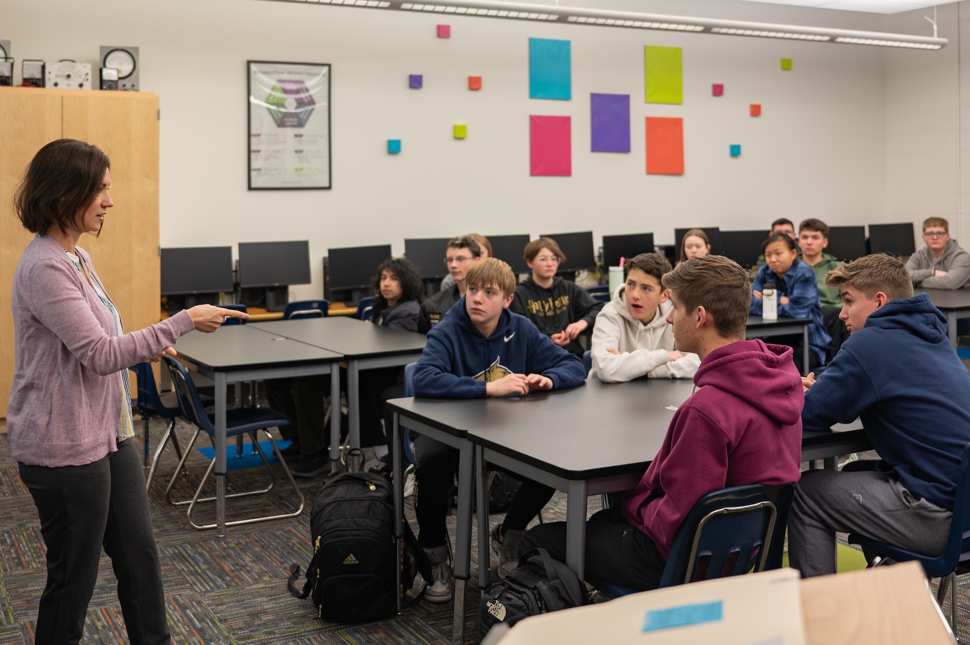 An individual stands in front of a class of students