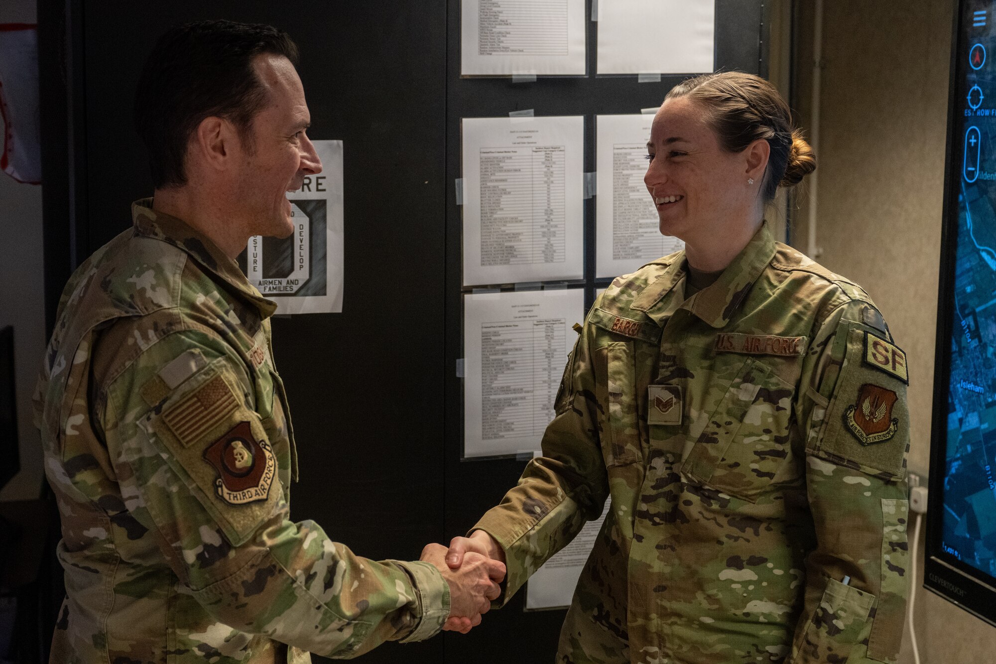 U.S. Air Force Maj. Gen. Paul Moga, left, Third Air Force commander, coins Staff Sgt. Samantha Barger, 100th Security Forces Squadron flight sergeant, at RAF Mildenhall, England, Jan. 28, 2025. Moga visited to learn about the 100th Air Refueling Wing’s daily operations, and recognized outstanding Airmen around the installation for their contribution to the mission. (U.S. Air Force photo by Senior Airman Christopher Campbell)