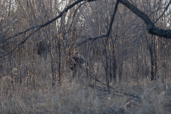 Man in camouflage sneaking in woods