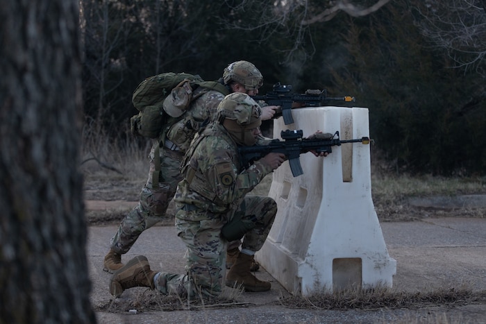 Airmen firing rifles from behind cover