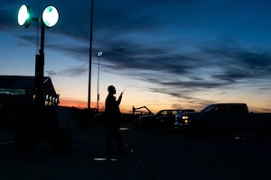A man stands in a setting sun with a radio
