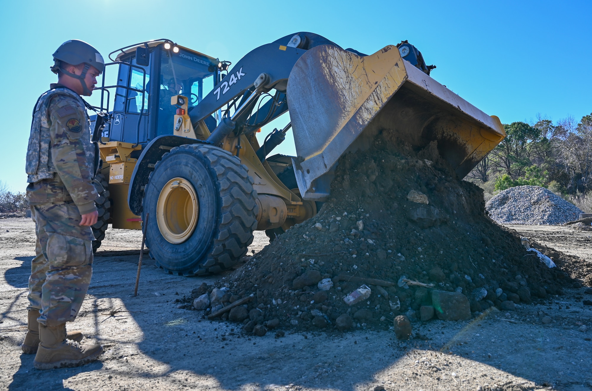 Airman stares at Dump truck and dirt pile