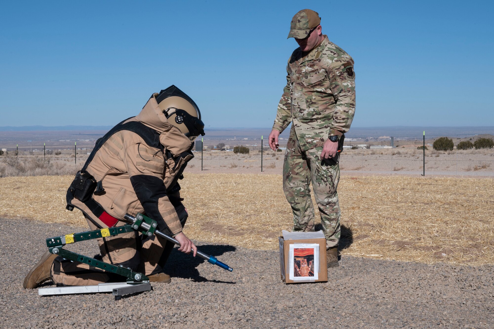A man uses EOD equipment in a bomb resistant suit.