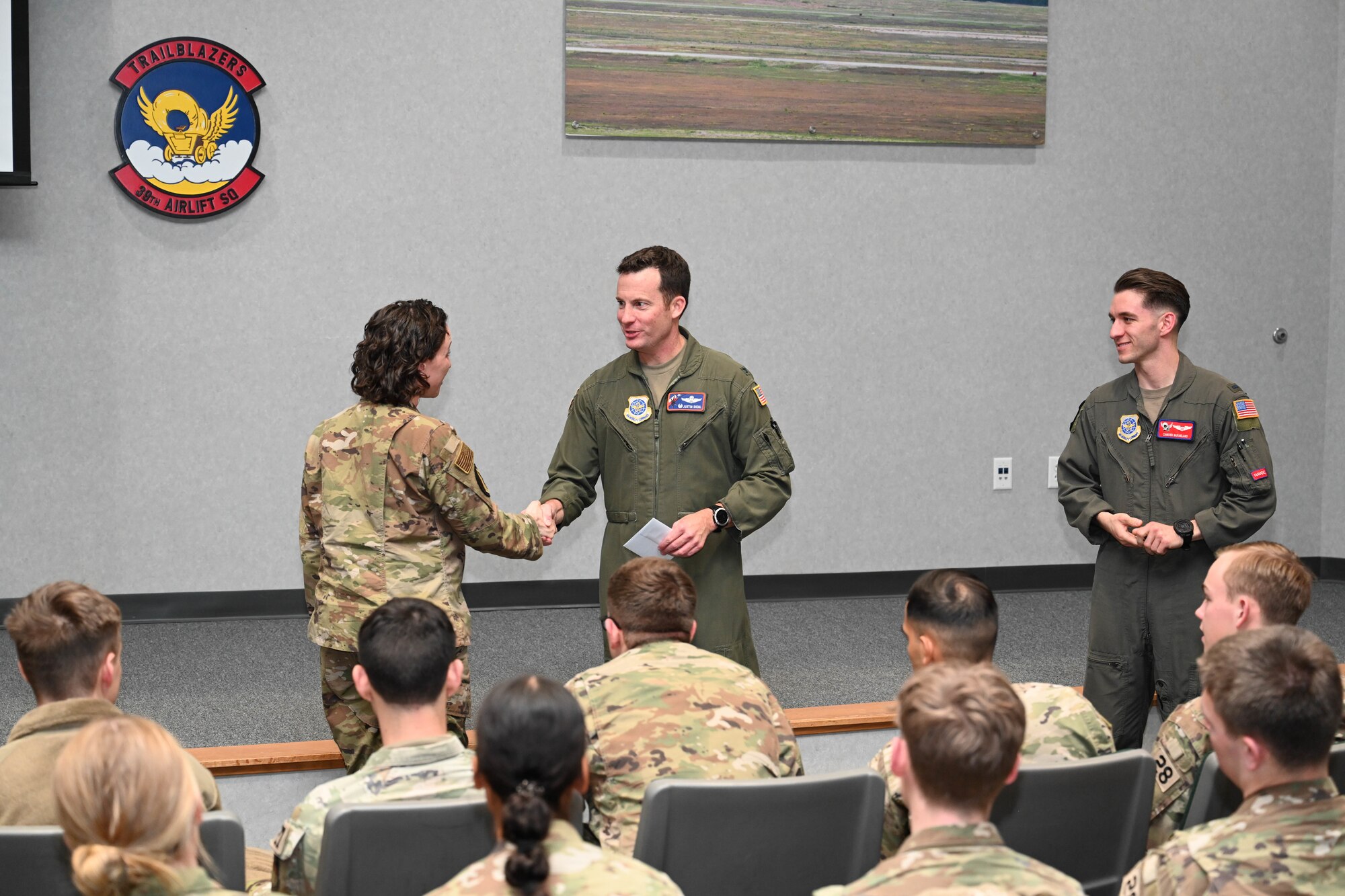 U.S. Air Force Col. Justin Diehl, 317th Airlift Wing commander, shakes hands with Maj. Sydney Freeman, U.S. Air Force Academy 28th Cadet Squadron commander, during a tour at Dyess Air Force Base, Texas, Jan. 30, 2025. The tour gave the cadets the opportunity to get hands-on operational experience while seeing how Dyess impacts the overall mission. These interactions aid cadets in understanding the essential role of rapid global mobility, the power of joint and coalition partnerships, and the innovation necessary to project, connect, maneuver, and sustain combat power anywhere in the world. (U.S. Air Force photo by Airman Caleb Schellenberg)