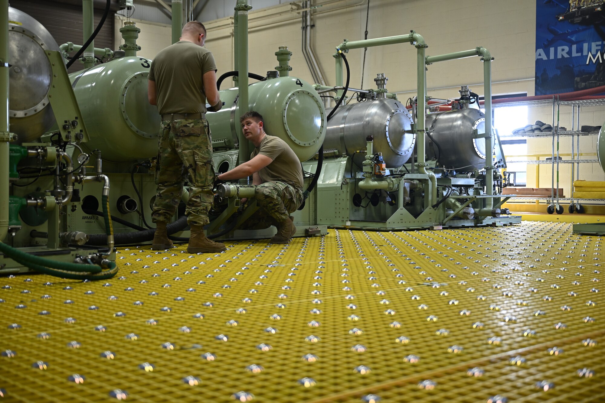 U.S. Air Force Staff Sgts. Joseph Hackett and Dylan Miller, both aerial spray maintenance technicians with the 910th Maintenance Squadron, work on a legacy module aerial spray system on Feb. 1, 2025, at Youngstown Air Reserve Station, Ohio.