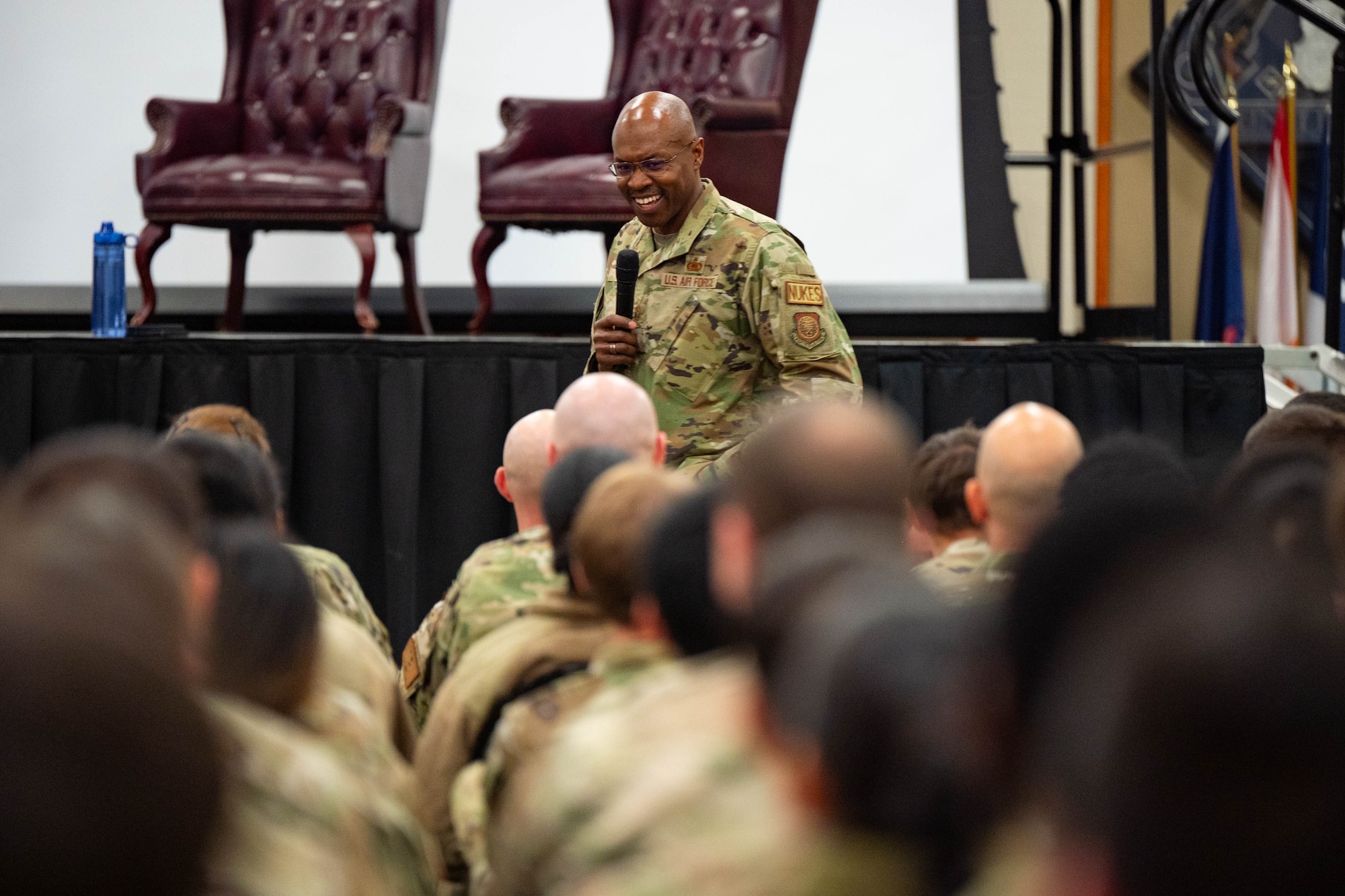 A man in uniform speaks to a crowd of uniformed personnel.