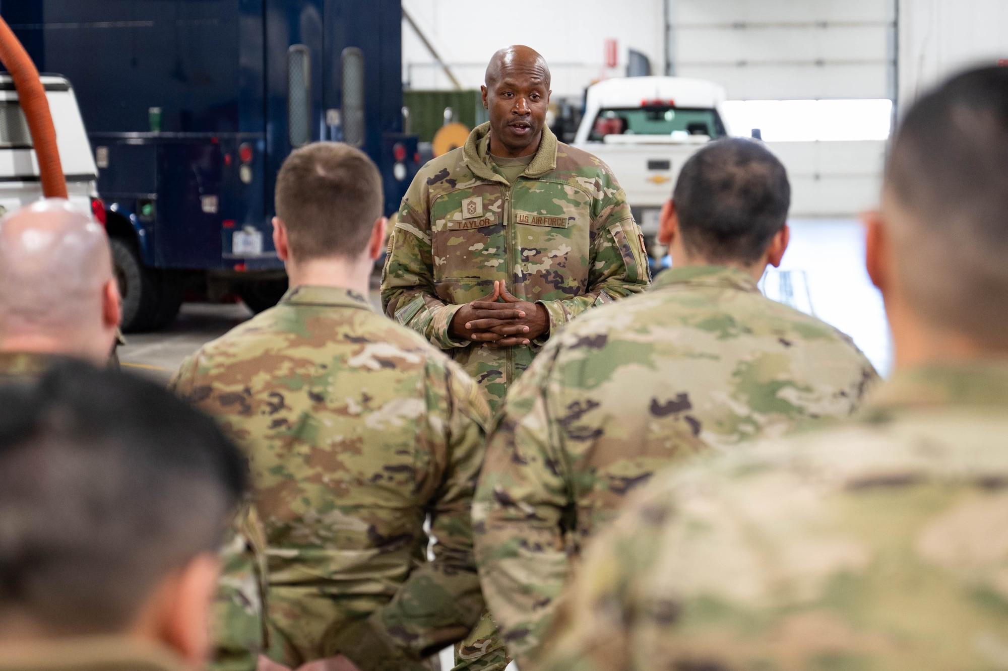 A man in uniform speaks to a crowd of uniformed personnel.
