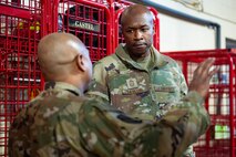 A man in uniform speaks with another man in uniform.