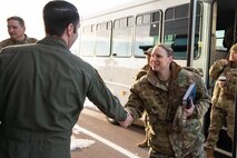 A woman in uniform shakes hands with a man in uniform.