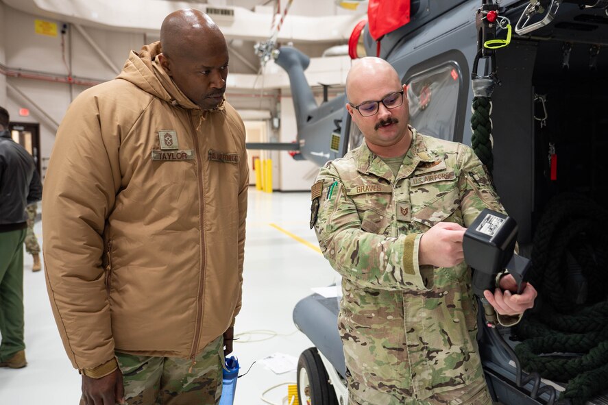 A man in uniform explains something to another man in uniform.