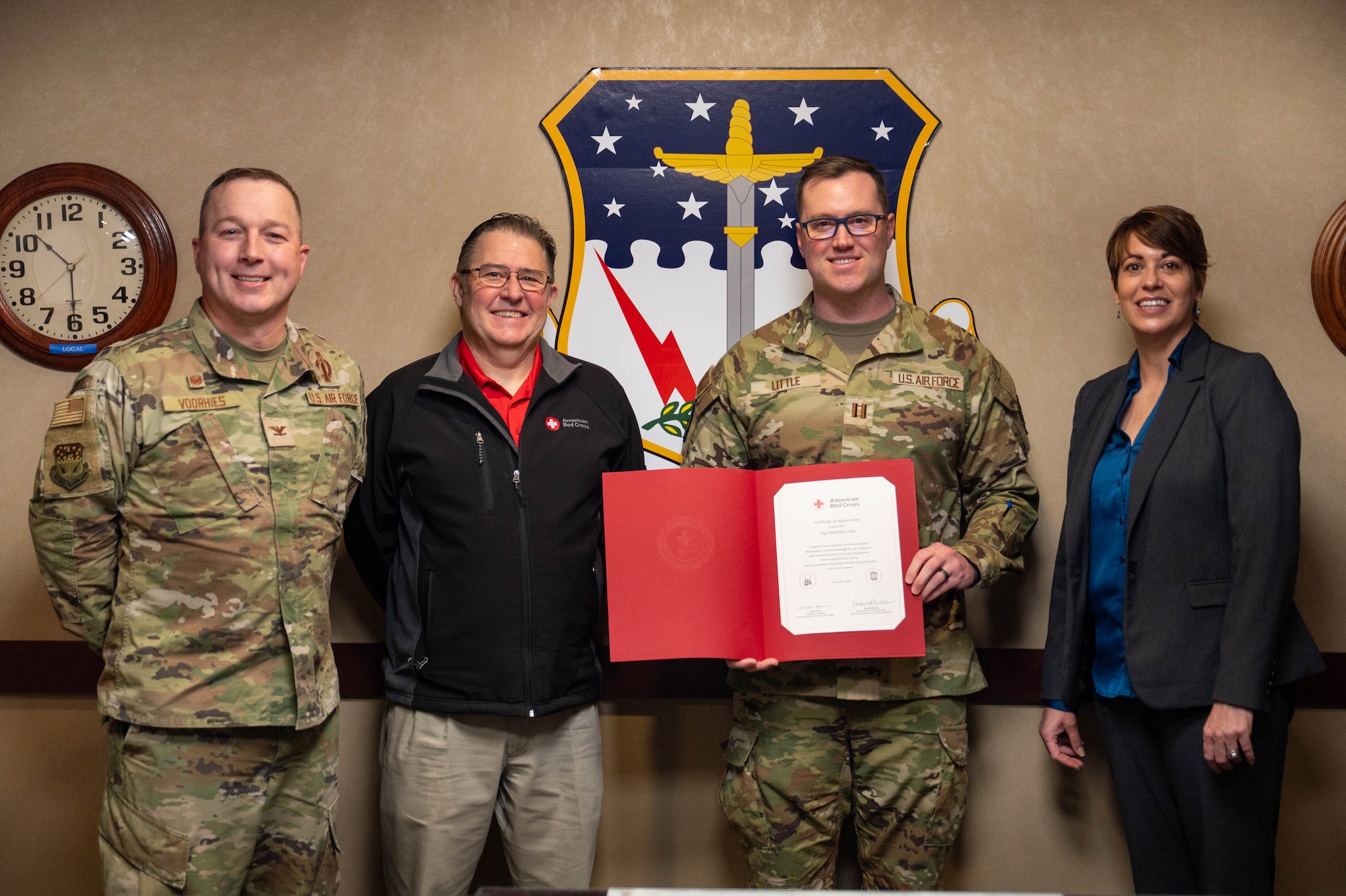 A group of people stand together with a certificate of appreciation.