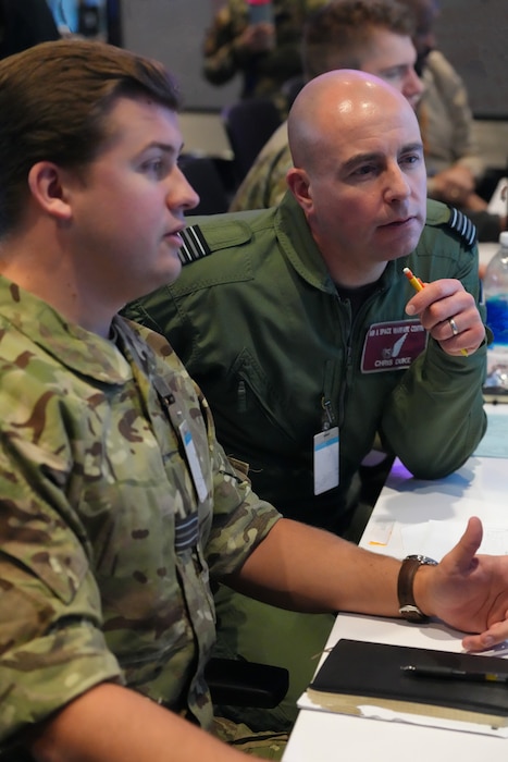 photo of Two United Kingdom members work on computers