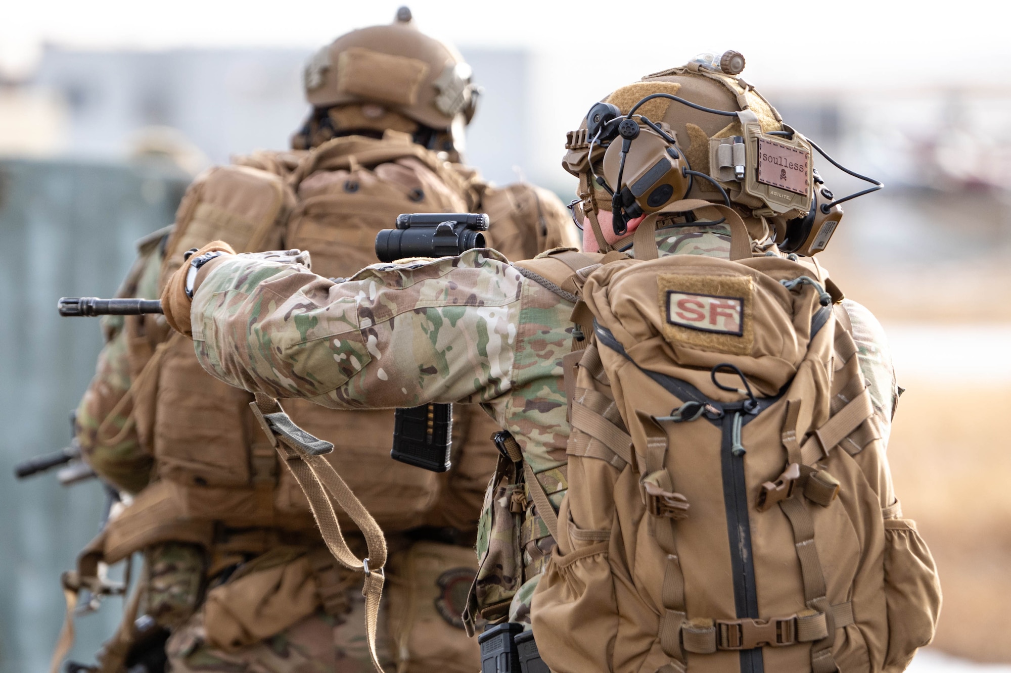 A man in uniform points his weapon.
