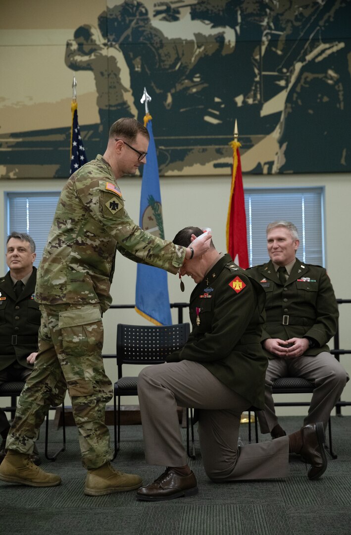 Lt. Col. Brandon Spradlin, commander for the 1st Squadron, 180th Cavalry Regiment, inducts Col. Shane Riley into the Order of Saint George during his retirement ceremony held at the Norman Armed Forces Reserve Center in Norman, Oklahoma, Feb. 1, 2025. The Order of Saint George is an award given to members of the United States Army's cavalry and armor units recognizing outstanding service, and is given by the United States Armor Association. (Oklahoma National Guard Photo by Spc. Cambrie Cannon)