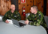 FORT INDIANTOWN GAP, Pa. – Swedish Army Lt. Col. Lt. Col. Fredrik Mansson (left), the chief of operations for the 1st Division Headquarters, speaks with Swedish Army Lt. Col. Jesper Sparre about 42nd Infantry Division command post procedures during the 42nd Inf. Div.’s Warfighter 25-3 exercise at Fort Indiantown Gap, Pa., Jan. 31, 2025.