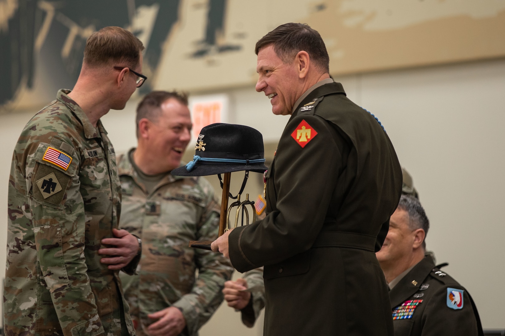 Col. Shane Riley receives a cavalry stetson and spurs from Lt. Col. Brandon Spradlin and Command Sgt. Maj. Justin Parker, the command team for the 1st Squadron, 180th Cavalry Regiment, during Riley’s retirement ceremony held at the Norman Armed Forces Reserve Center in Norman, Oklahoma, Feb. 1, 2025. Riley’s last assignment was director of Unmanned Aerial Systems and Launched Effects Program for the Oklahoma Army National Guard, and his career spanned 36 years and included four deployments. (Oklahoma National Guard Photo by Spc. Brooklyn Clark)